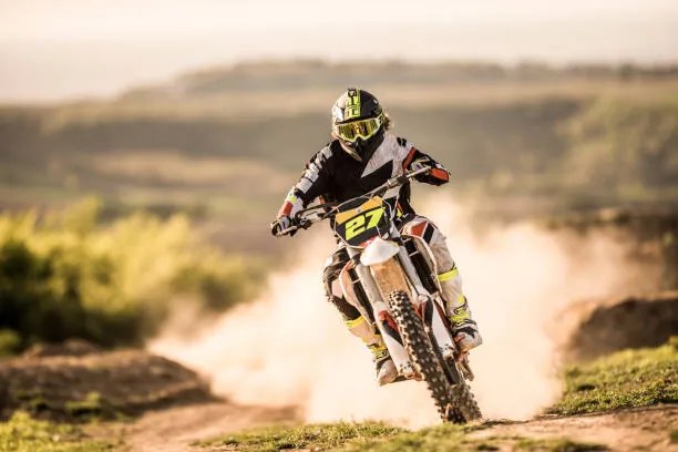 Fotografie Man on dirt bike racing on dirt road in nature., skynesher