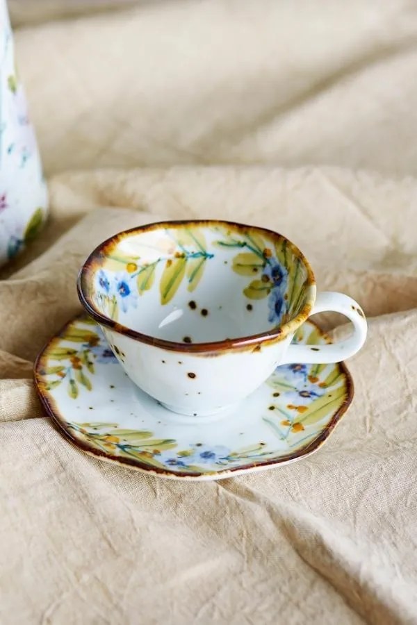 Set 4 căni cu farfurioară din ceramică artizanală albă cu motive florale pastelate pictate manual și margine maro, 15×7,5 cm, "Savina"