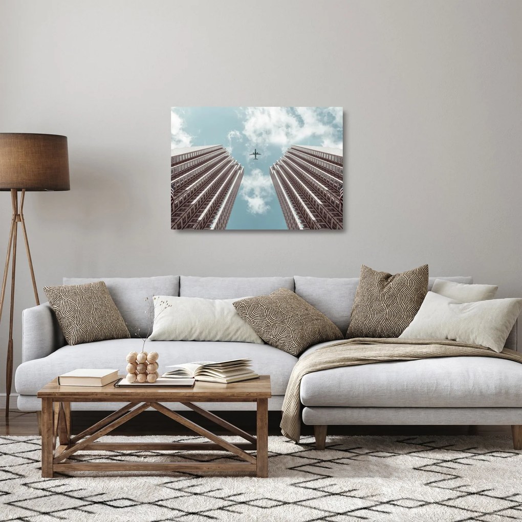 Tablou pe sticlă cuavion între clădiri (70x50 cm)