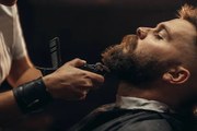 Fotografie Young bearded man getting beard haircut, zamrznutitonovi