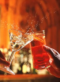 Fotografie Couple clinking glasses, spilling drink, close-up, Peter Dazeley