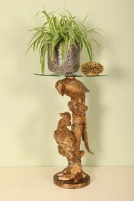 Măsuță laterală sculptată rotundă, auriu, cu bază în formă de papagali pe trunchi și blat din sticlă, finisaj antichizat, 62 x 40 cm, „Cacatoès”